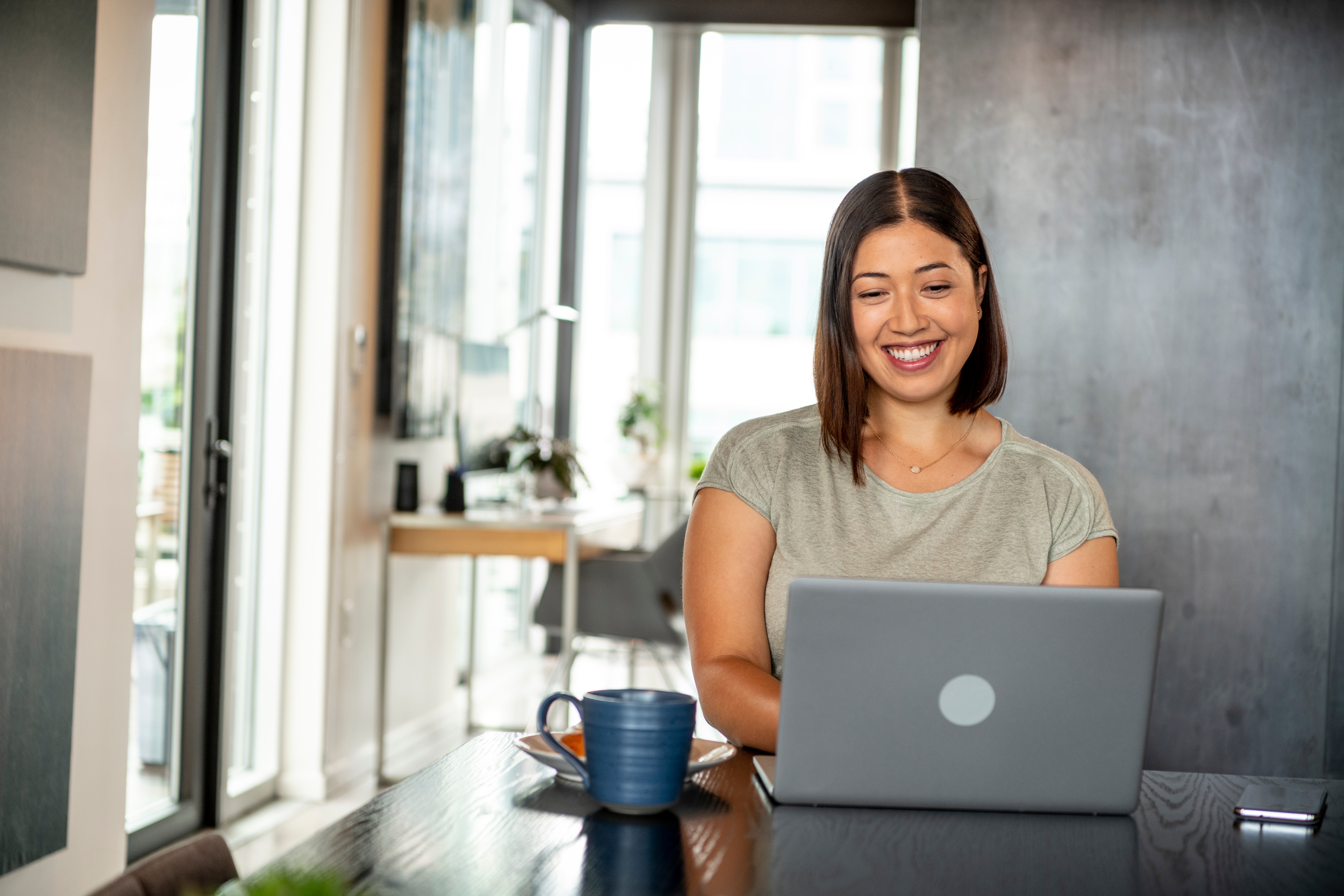 Woman doing her accounts payable from home with a cup of coffee