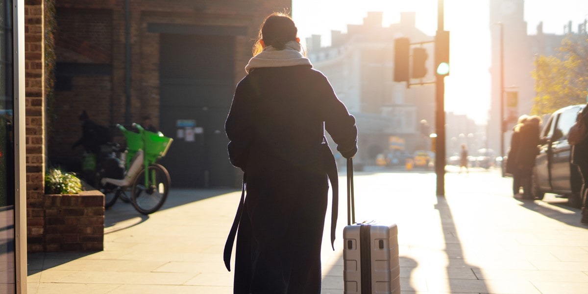 traveler walking through city with suitcase